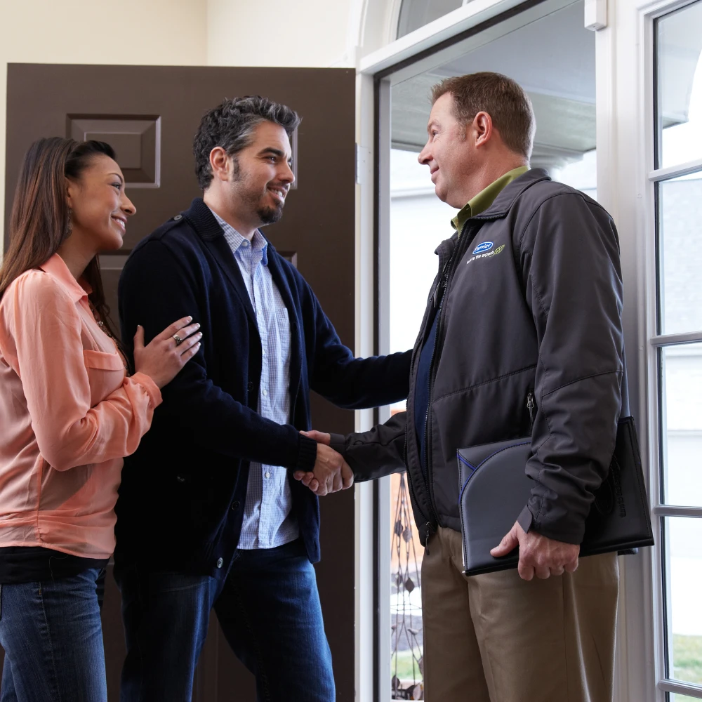 tech shaking mans hand in front of door